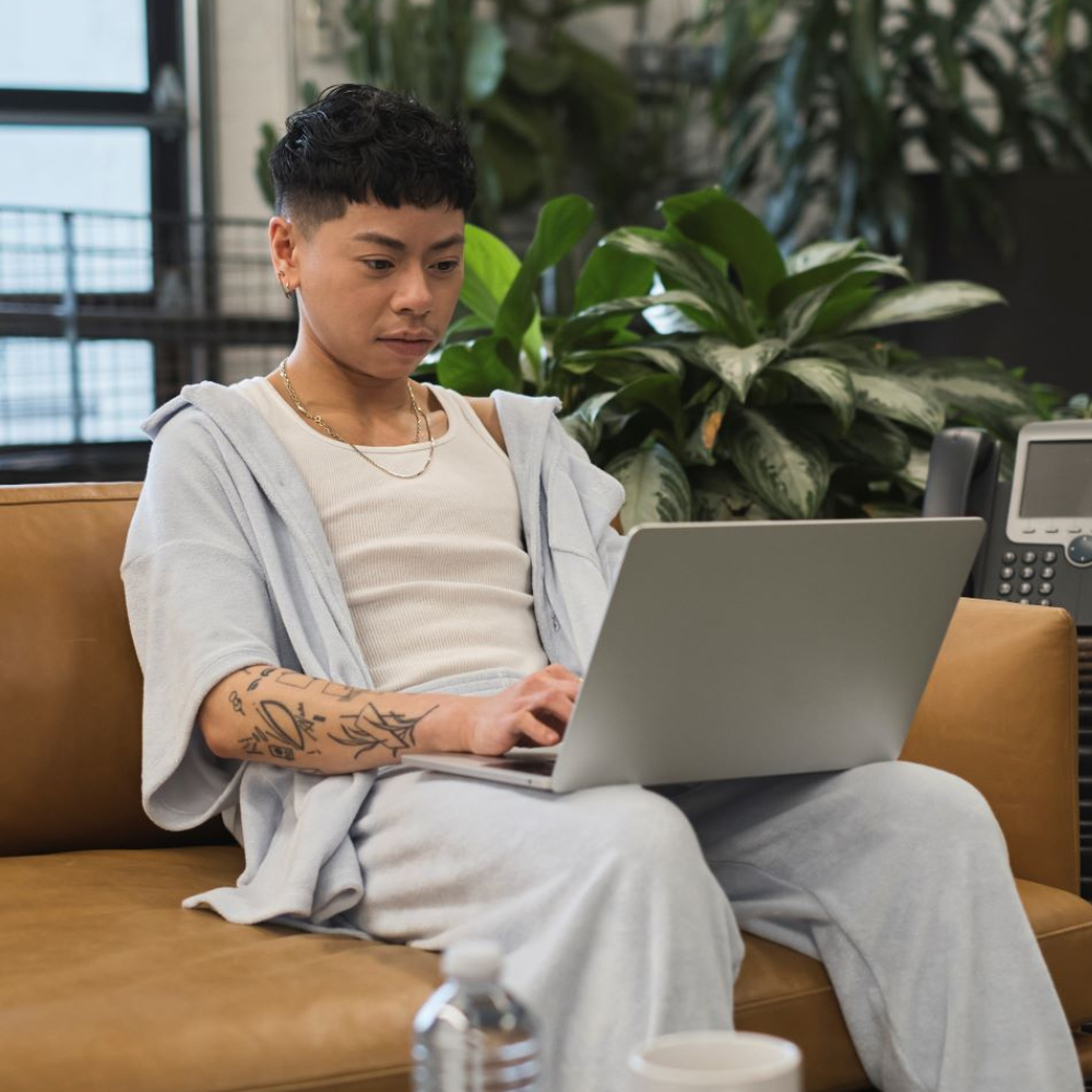 A non-binary person using a laptop