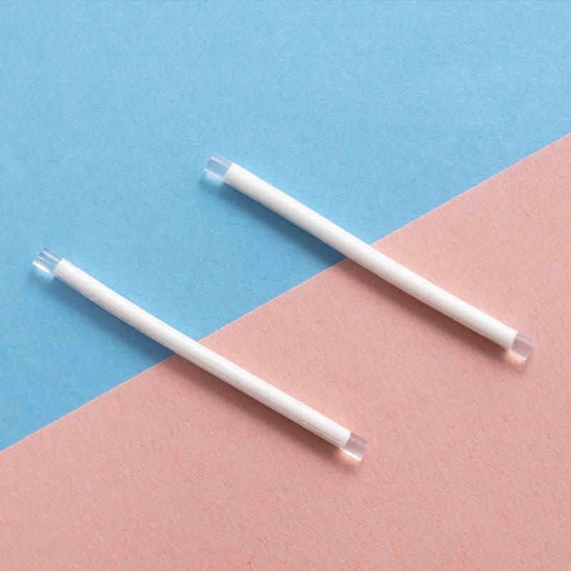 The Implant form of birth control in the insertion tool against a blue and pink background.
